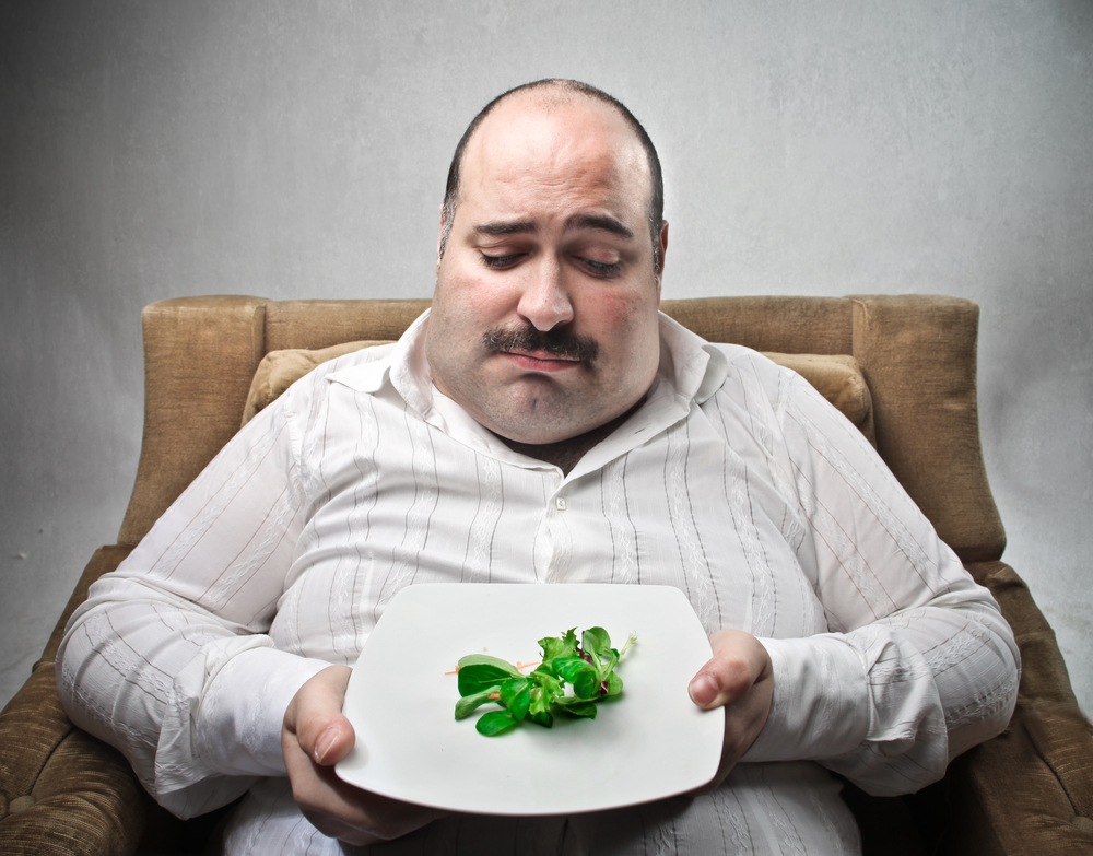 Sad Fat Man Looking At His Dish Containing Barely Salad